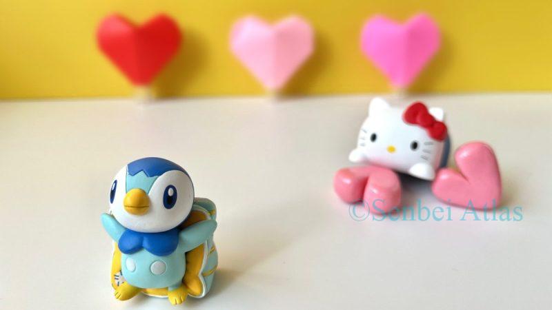 Hello Kitty (ハローキティ) giving 'Honmei' chocolate (本命チョコ) to Piplup (ポッチャマ), who shyly looks away with his back turned in a scene of Japanese Valentine's Day