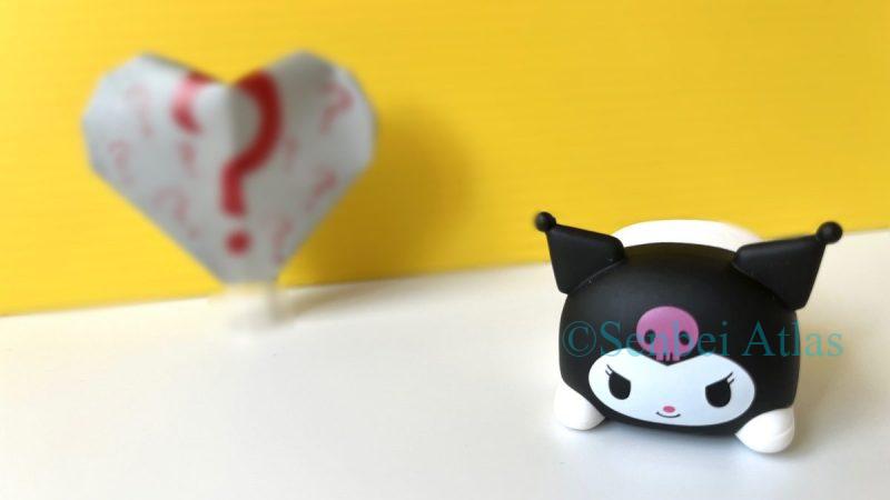 Kuromi (クロミ) with a gray heart featuring a question mark, representing the unique Japanese culture of 'Giri' chocolate (義理チョコ) given as a social obligation.