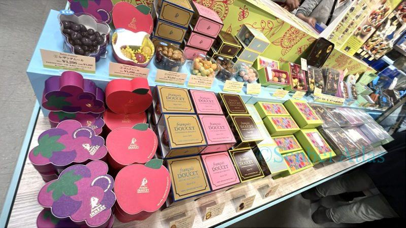 An exhibition of François DOUCET (フランソワ デュセ) chocolates at the Amour du Chocolat (アムール・デュ・ショコラ) Valentine's Day event (バレンタイン催事) at Shinjuku Takashimaya (新宿高島屋). Colorful and cute packages featuring grape and apple designs are lined up for the Valentine's Day event.