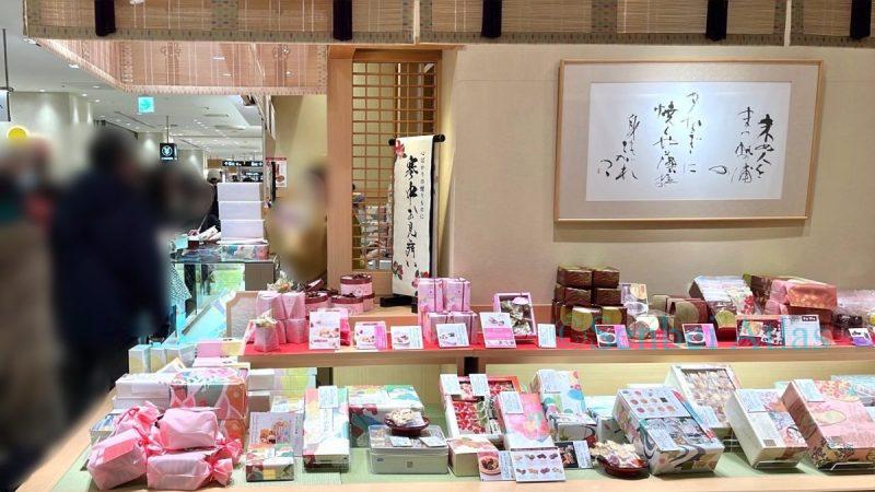 Exterior of Ogura Sansou shop with a traditional Japanese atmosphere, featuring bamboo blinds (Misu), calligraphic art, and a display of Valentine's senbei.