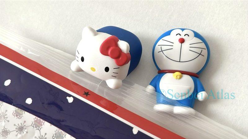 A close-up of Hello Kitty and Doraemon figures placed next to a Yuki no Yado package.