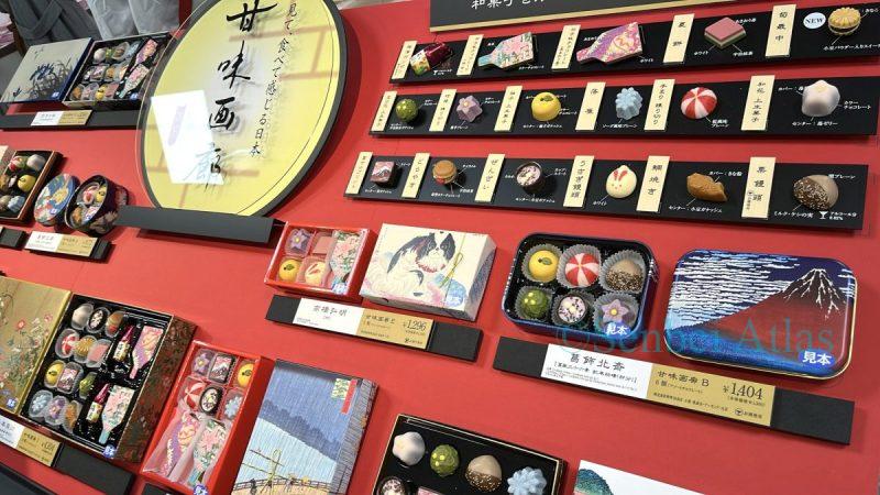 A display of KANMIGARO (甘味画廊) chocolates at the Amour du Chocolat (アムール・デュ・ショコラ) Valentine's Day event (バレンタイン催事) at Shinjuku Takashimaya (新宿高島屋). The exhibit features delicate chocolates shaped like Japanese sweets and tins printed with famous paintings, including Hokusai's Mt. Fuji (北斎の富士山).