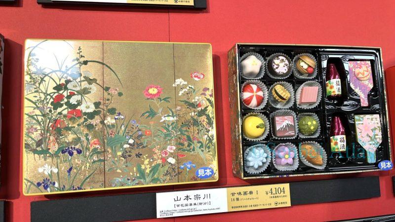 KANMIGARO (甘味画廊) chocolates at the Amour du Chocolat (アムール・デュ・ショコラ) event (バレンタイン催事) in Shinjuku Takashimaya (新宿高島屋). The chocolates look like Japanese sweets (和菓子) and feature the golden artwork of Yamamoto Sosen (山本惣一) on the packaging, giving them a luxurious and elegant appearance.
