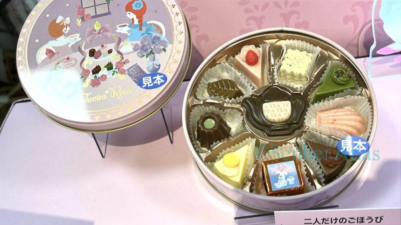 A round tin of Twotea Room (トゥーティー・ルーム) chocolates titled 'A Reward for Just the Two of Us' (二人だけのごほうび). Inside are adorable chocolates shaped like a teapot , madeleines, shortcakes, matcha cakes, and canelés.