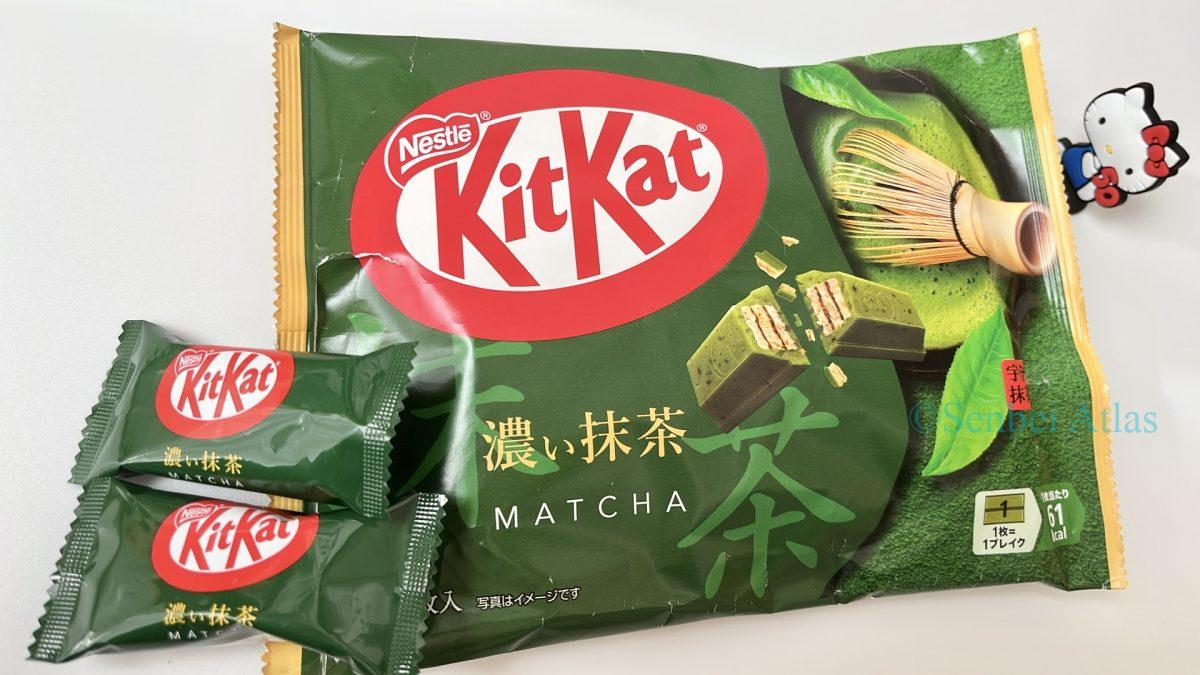 Package of Kit Kat Deep Matcha (キットカット 濃い抹茶) with two individually wrapped bars on top and a Hello Kitty (ハローキティ) figure in the background on the right.