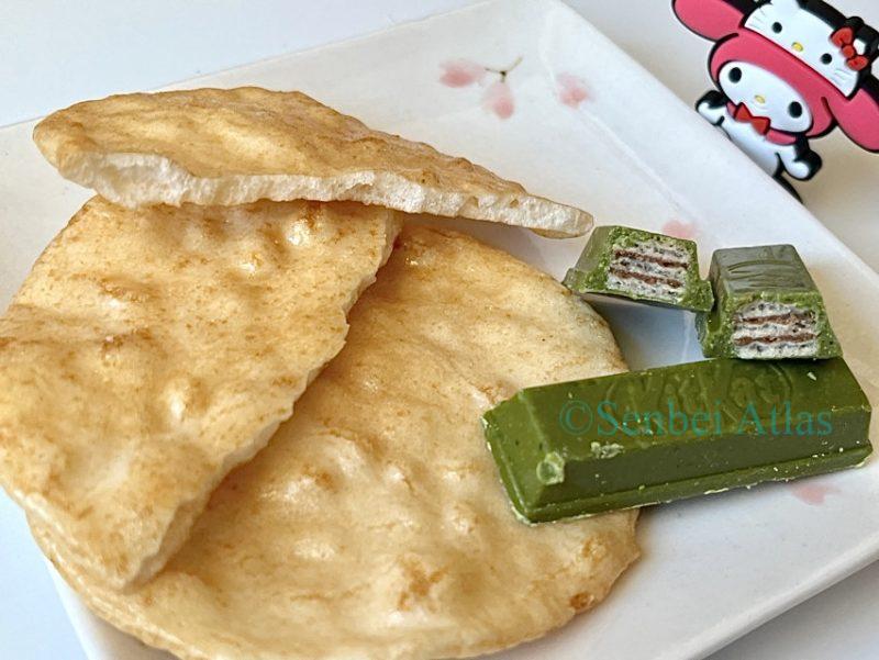 A cross-section of Matcha KitKat and Magari Senbei (Japanese rice crackers)  lies on a plate, with My Melody behind it.