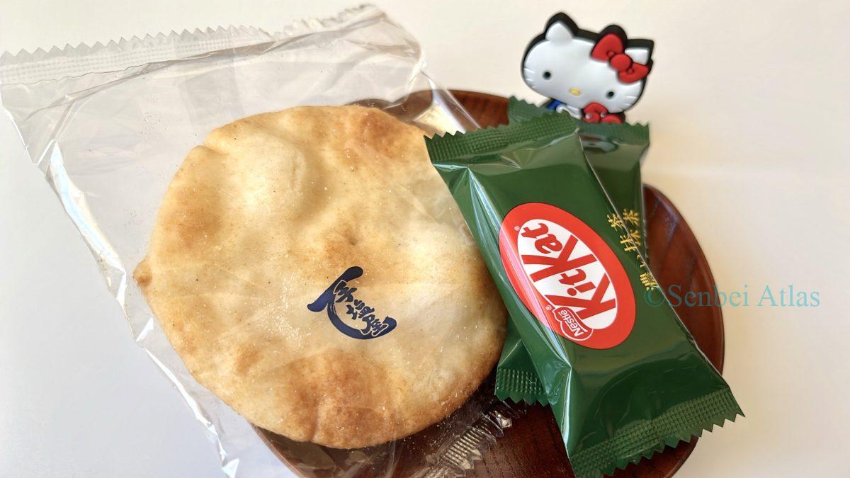 Matcha KitKat and Teshioya sit on a plate, with Kitty behind them.