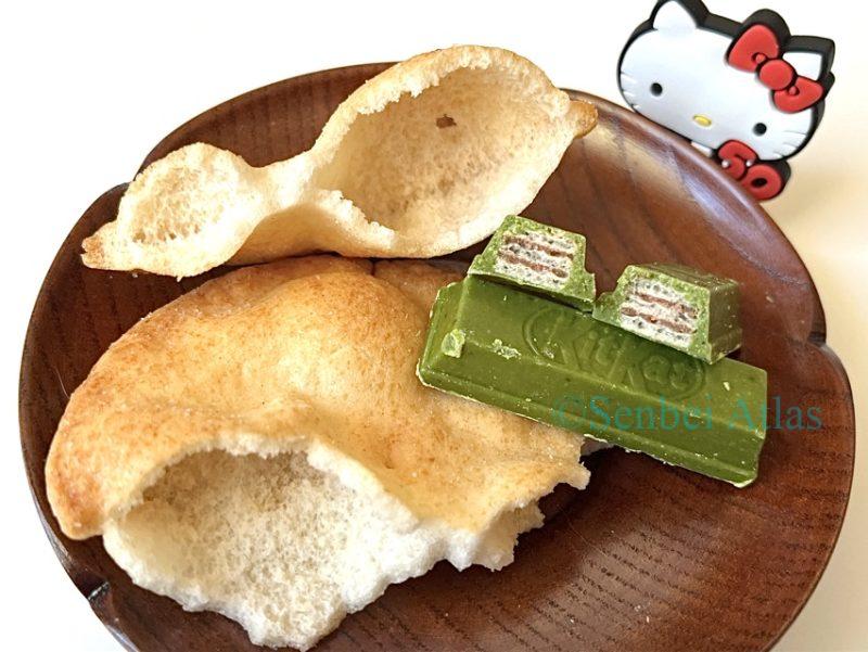 A cross-section of Matcha KitKat and Teshioya lies on a plate, with Kitty behind it.