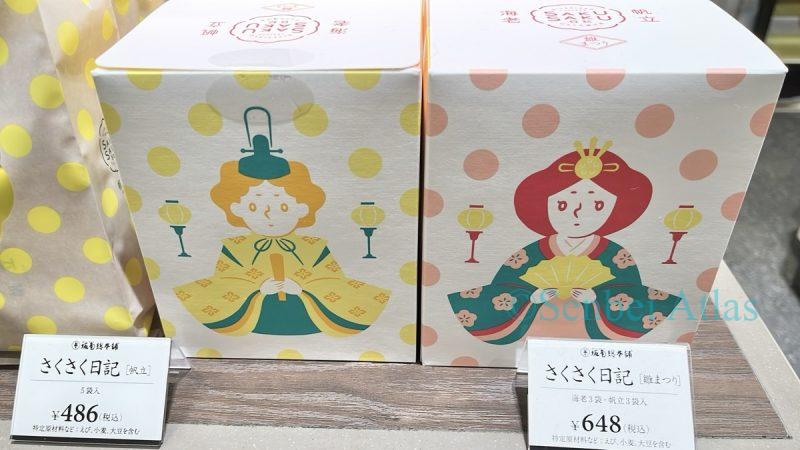 Saku Saku Nikki (さくさく日記) by Bankaku Sohonpo (坂角総本舖) in Hinamatsuri (ひなまつり) themed prince and princess packages at a store.