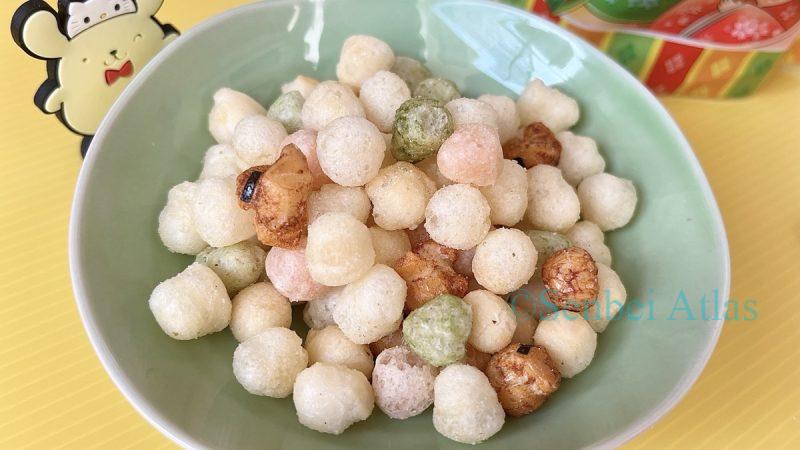 Close-up of Hina Arare (ひなあられ) on a plate with Pompompurin (ポムポムプリン) in the background.