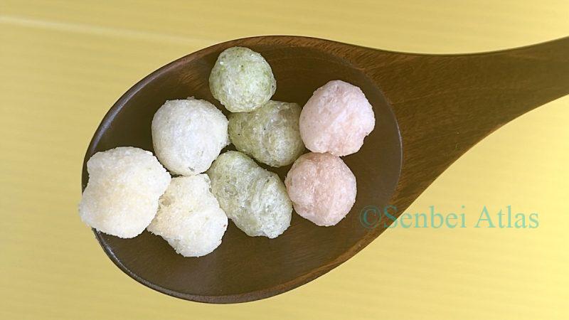 A wooden spoon holding Echigo Seika (越後製菓) Hina-arare (ひなあられ), one of Japan's savory umami rice snacks.