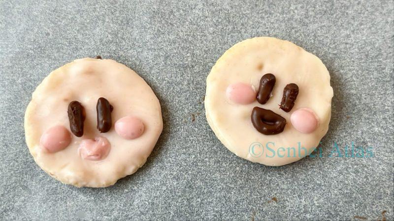 A failed Kirby (カービィ) chocolate senbei (せんべい) with unintentionally thick lips that don't quite look like Kirby.