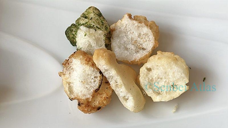 Cross-section of a savory snack from Ginza Akebono (銀座あけぼの) Hina-arare (ひなあられ) showing its dense texture.