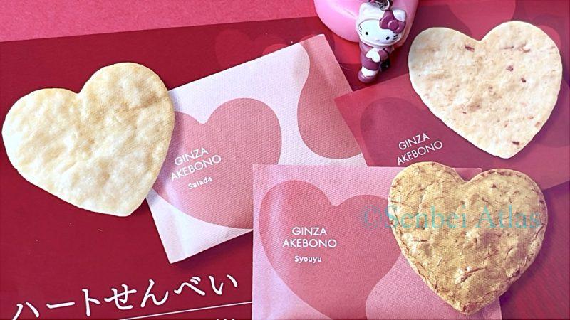 Three heart-shaped rice crackers on a Ginza Akebono (銀座あけぼの) brochure for Valentine’s Day gifts with a dressed-up Hello Kitty (ハローキティ) figure.