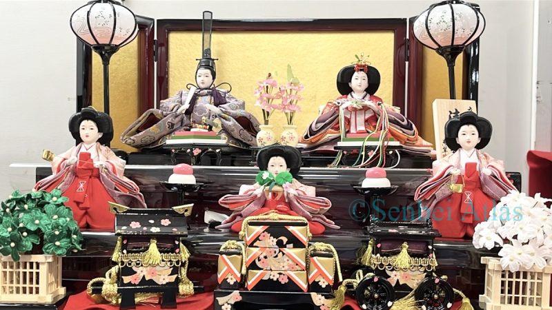 A two-tiered Hinadan (ひな壇) display with Obina (男びな) and Mebina (女びな) on the top tier and Sannin-kanjo (三人官女) (Three Court Ladies) on the lower tier.