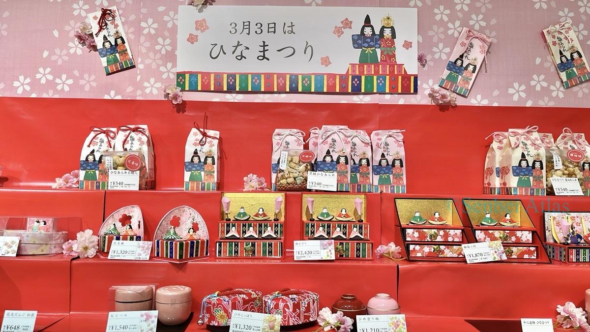 Hina-arare (ひなあられ) and Hinamatsuri (ひなまつり) items displayed on a traditional vermilion tiered stand.