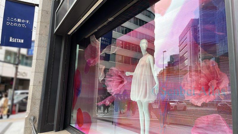 The spring-themed show window of Isetan Shinjuku (伊勢丹新宿), decorated with large pink flowers and a pink dress.