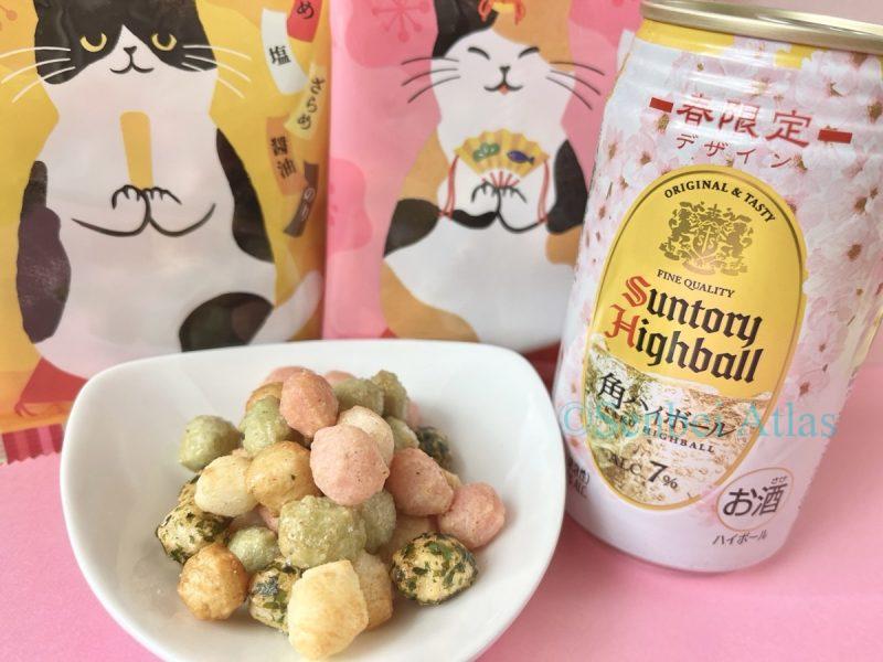 Kaldi (カルディ) Hinya-arare (ひにゃあられ) on a plate with a spring-edition Suntory Kaku Highball (サントリー角ハイボール) can and cat-themed packages.