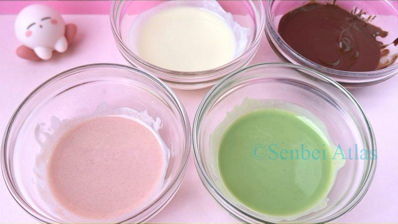 Four bowls containing melted strawberry, matcha, white, and milk chocolate, with a Kirby (カービィ) figure appearing in the background.