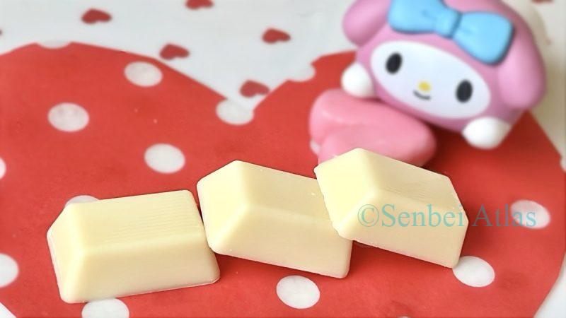 Three pieces of Morinaga Dars (森永ダース) white chocolate in the foreground with a My Melody (マイメロディ) character in the background.