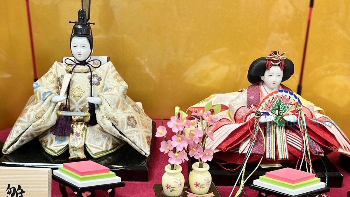 Obina (男びな) and Mebina (女びな) dolls displayed in front of a grand gold folding screen.