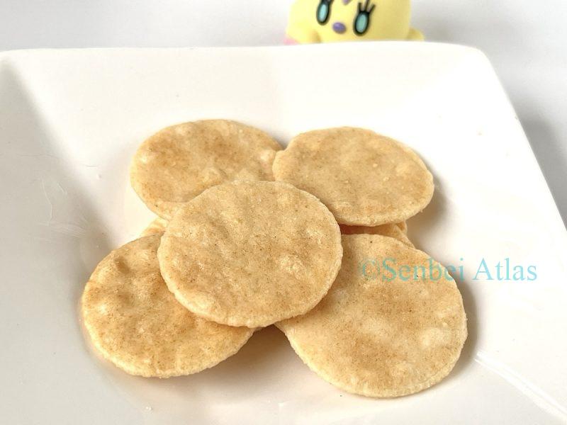 Bite-sized Petit Usuyaki crackers served on a plate with a Flittle (ヒラヒナ) figure in the background