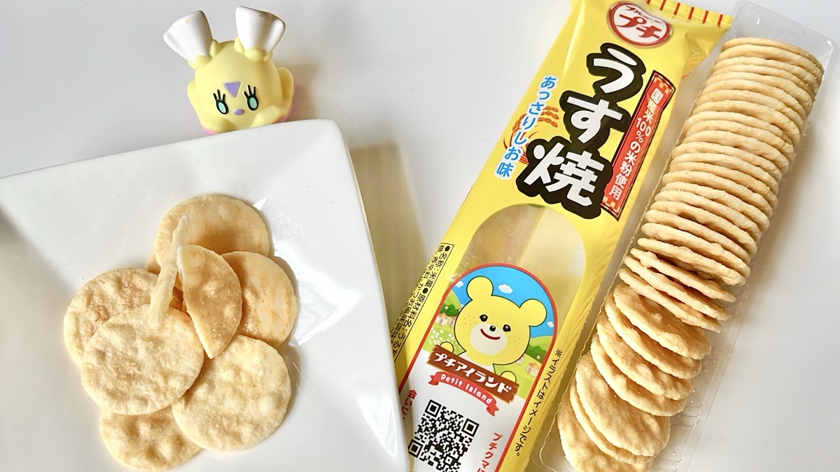 Petit Usuyaki (プチうす焼) package and bite-sized crackers with a Flittle (ヒラヒナ) figure in the background