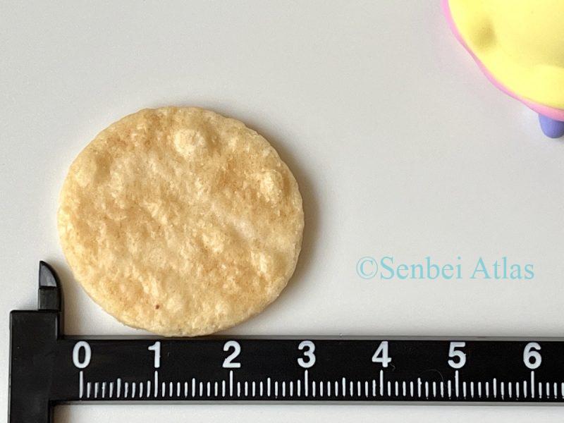 Petit Usuyaki cracker with a ruler underneath to show its coin-sized dimensions.
