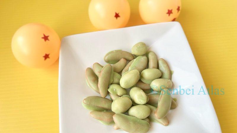 Green chocolate-coated senbei (せんべい) styled as Senzu Beans (仙豆) on a plate, featuring Dragon Balls (ドラゴンボール) in the background.