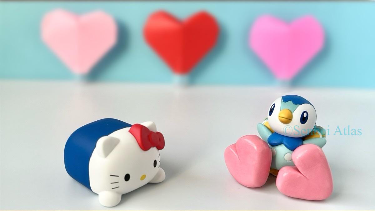 A White Day (ホワイトデー) themed photo of a Piplup (ポッチャマ) figure holding two hearts to give to a Hello Kitty (ハローキティ) figure.