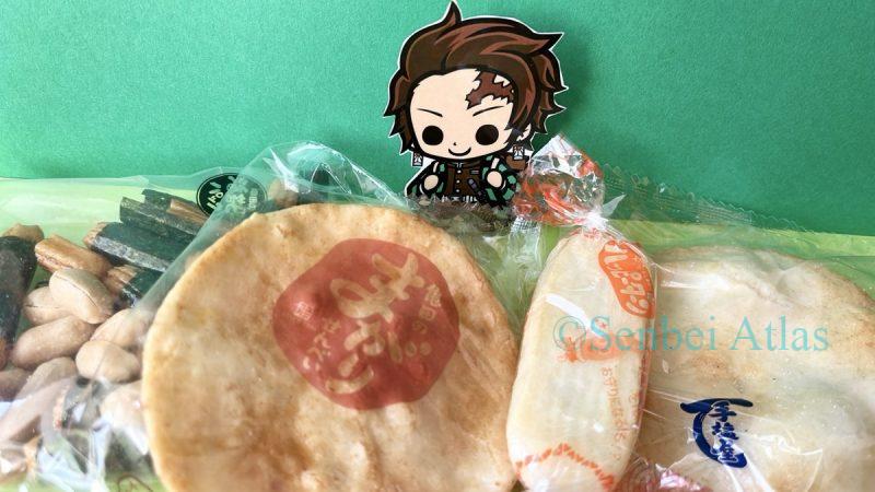 A character sticker of Tanjiro Kamado (炭治郎) surrounded by various types of Senbei (Japan's Savory Umami Rice Snacks)