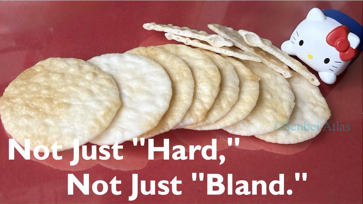 A row of thin senbei (薄焼きせんべい) on a plate, showing a cross-section with Hello Kitty (ハローキティ) in the background.