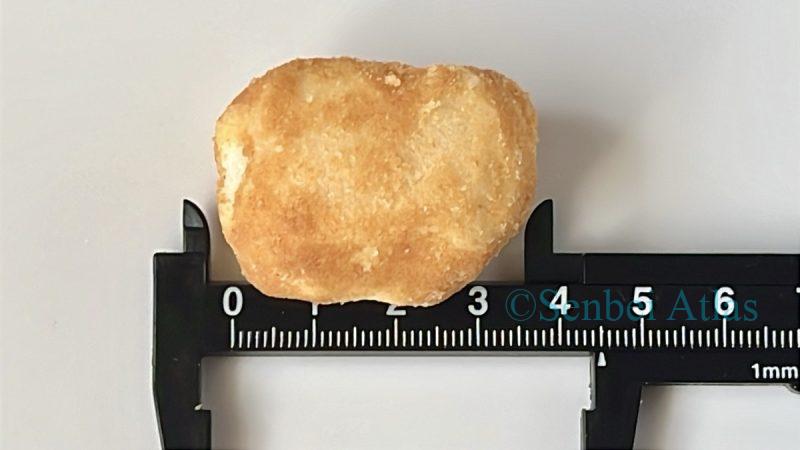 Measuring the size of a Funwari Meijin (ふんわり名人) rice cracker with a ruler.