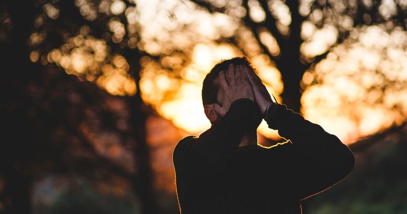A man covering his face with his hands.