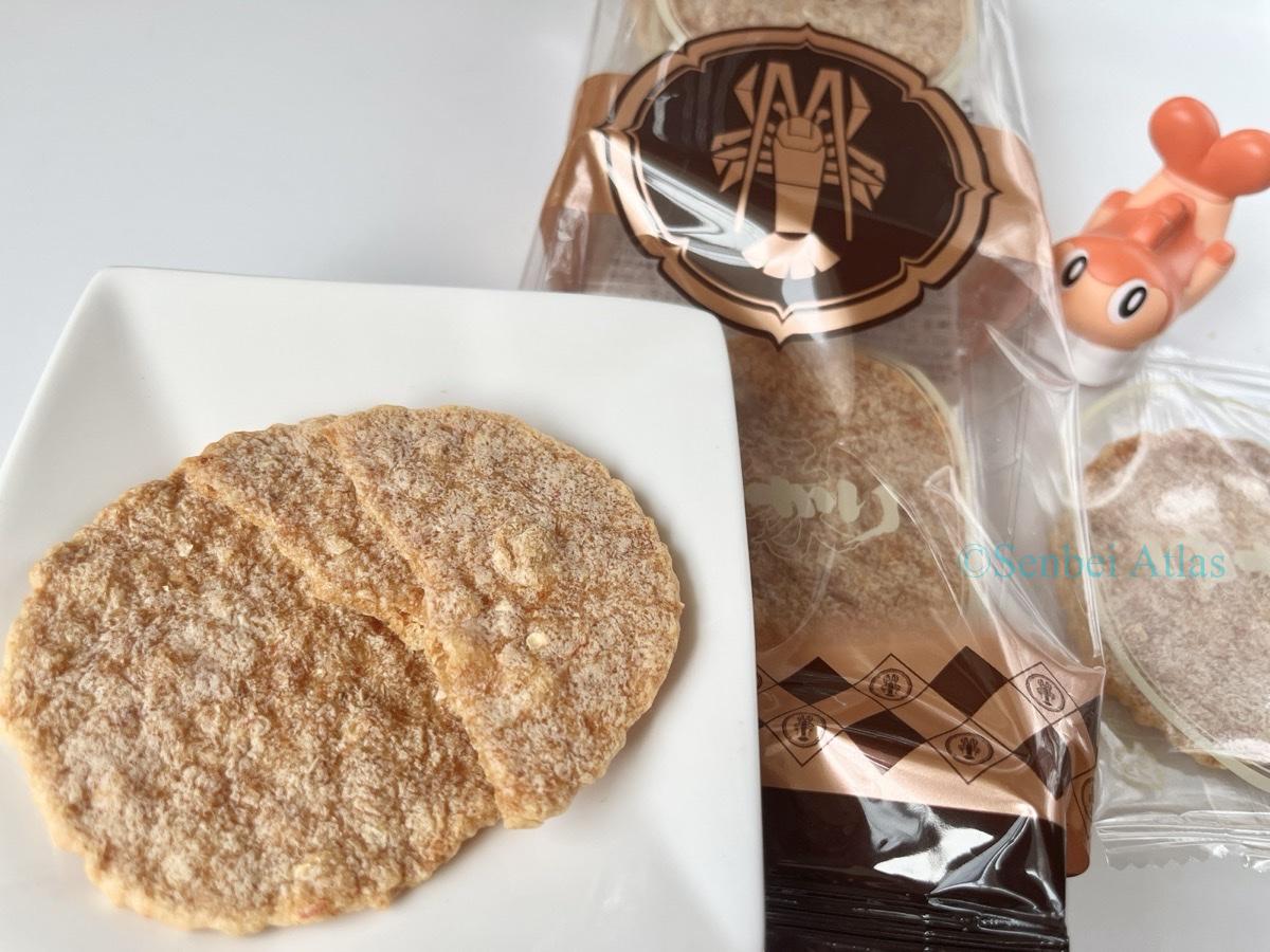 Yukari (ゆかり) package and its contents on a plate with Tatsugiri (シャリタツ) in the background.
